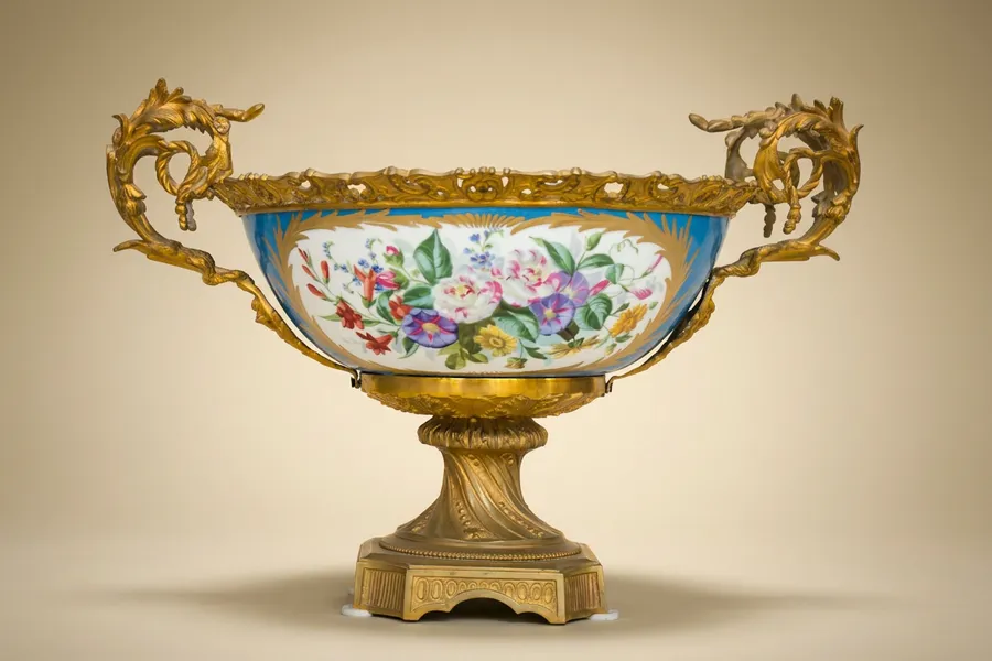 A Sevres style gilt bronze-mounted porcelain basket — Painted porcelain heightened with gilt, gilt-bronze mount — 19th century